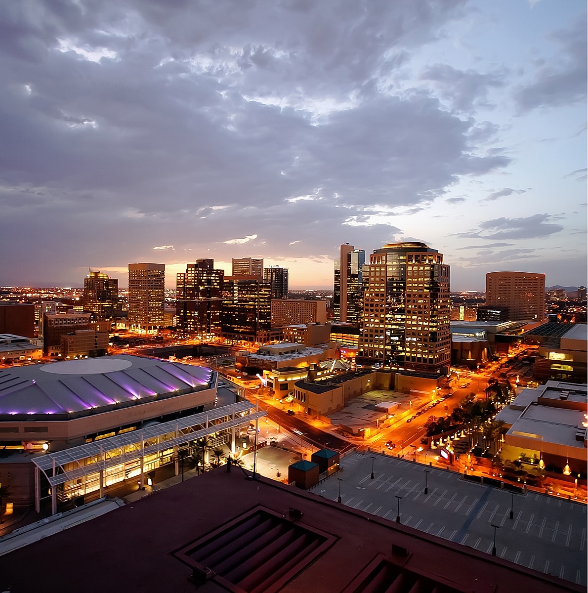 City skyline at dusk with illuminated buildings.