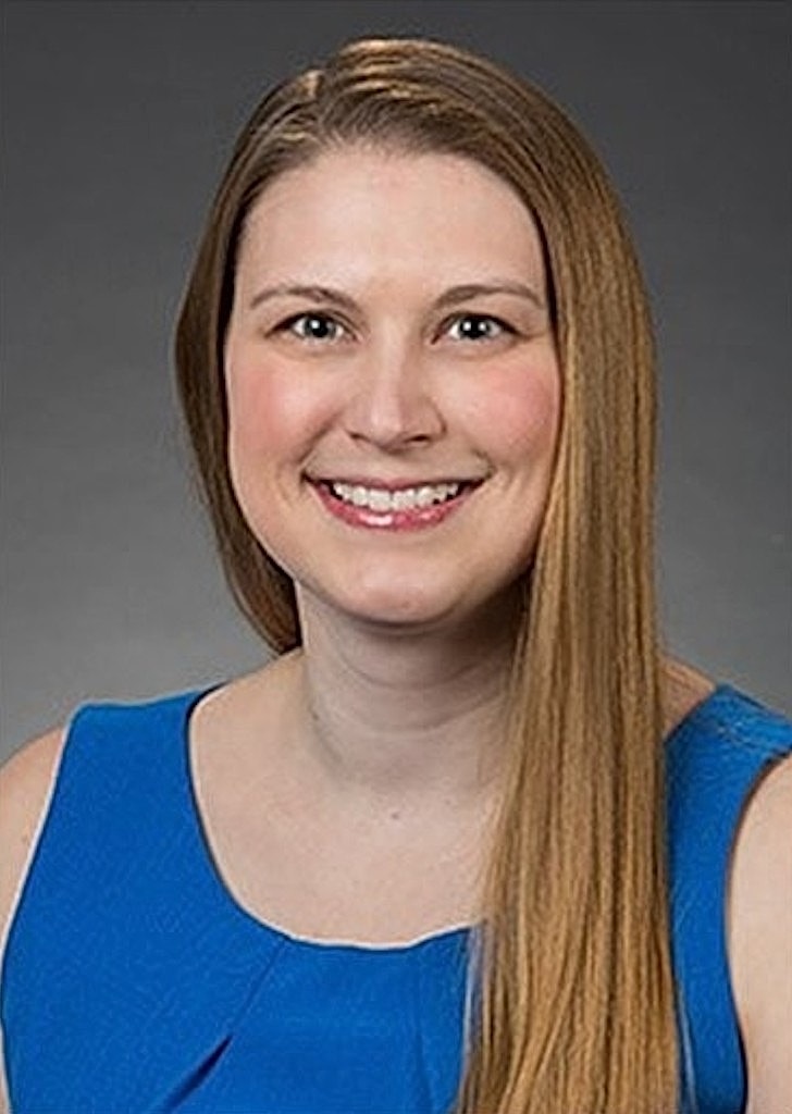 Smiling woman in blue dress portrait.