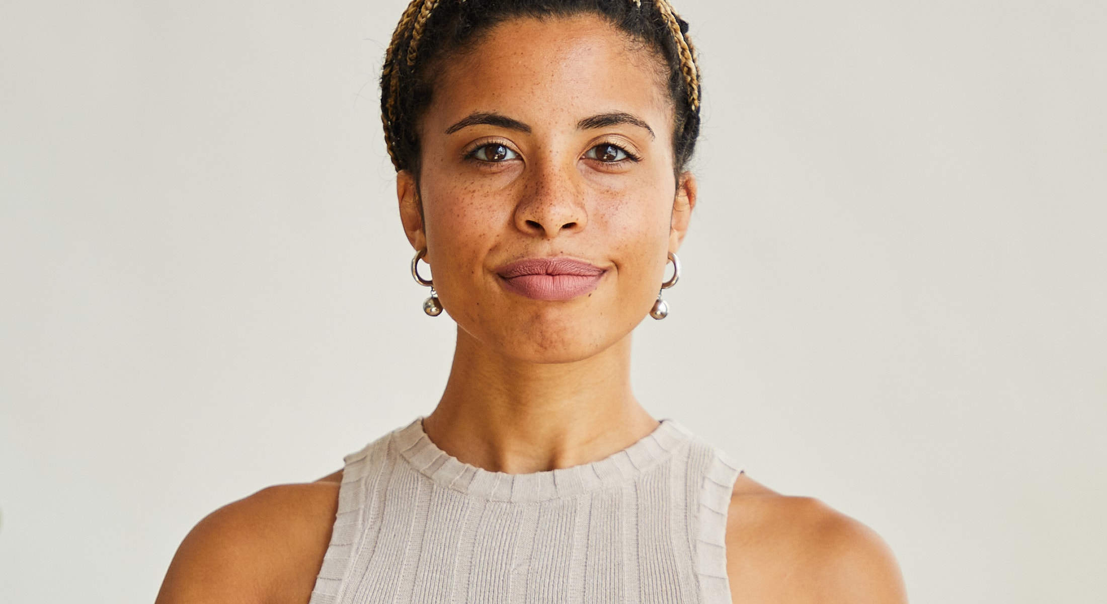 Person with braided hair and hoop earrings.